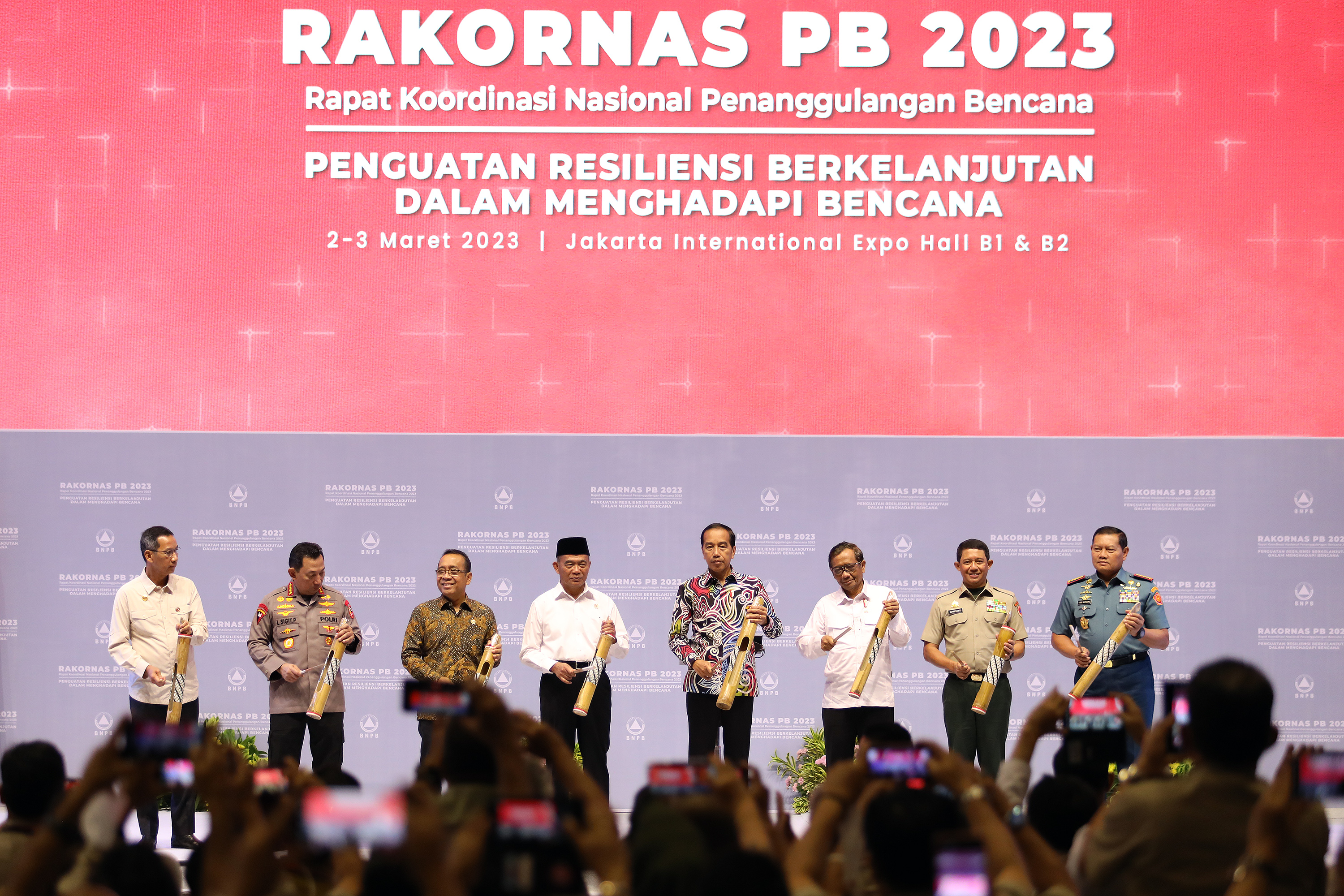 Presiden Joko Widodo (empat kanan) bersama Kepala BNPB Suharyanto (dua kanan), Panglima TNI Yudo Margono (kanan), Kapolri Listyo Sigit P (dua kiri), Mensesneg Pratikno (tiga kiri), Menko PMK Muhadjir Effendy (empat kiri) dan Menko Polhukam Mahfud MD (tiga kanan) memukul kentongan sebagai simbol pembukaan acara Rakornas PB BNPB 2023 di Jakarta International Expo (JiExpo) Kemayoran, Jakarta Pusat, Kamis (3/3). 